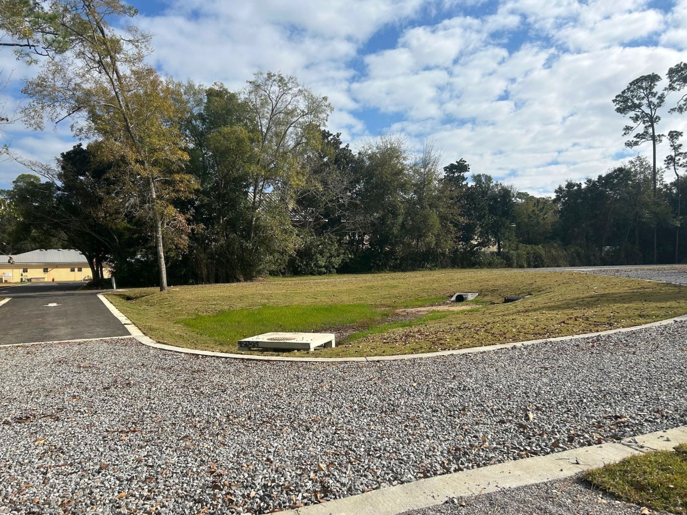 Retention pond area and gravel drive photo at Wind and Water Learning Center